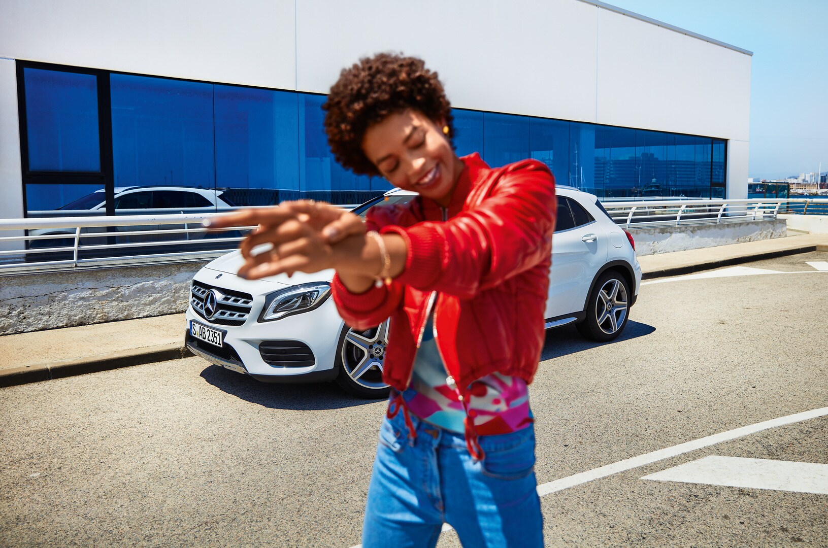 Une femme est dans une rue devant sa Mercedes blanche. | Mercedes-Benz Mercedes-Benz CompleteCare offre du temps pour l’essentiel...